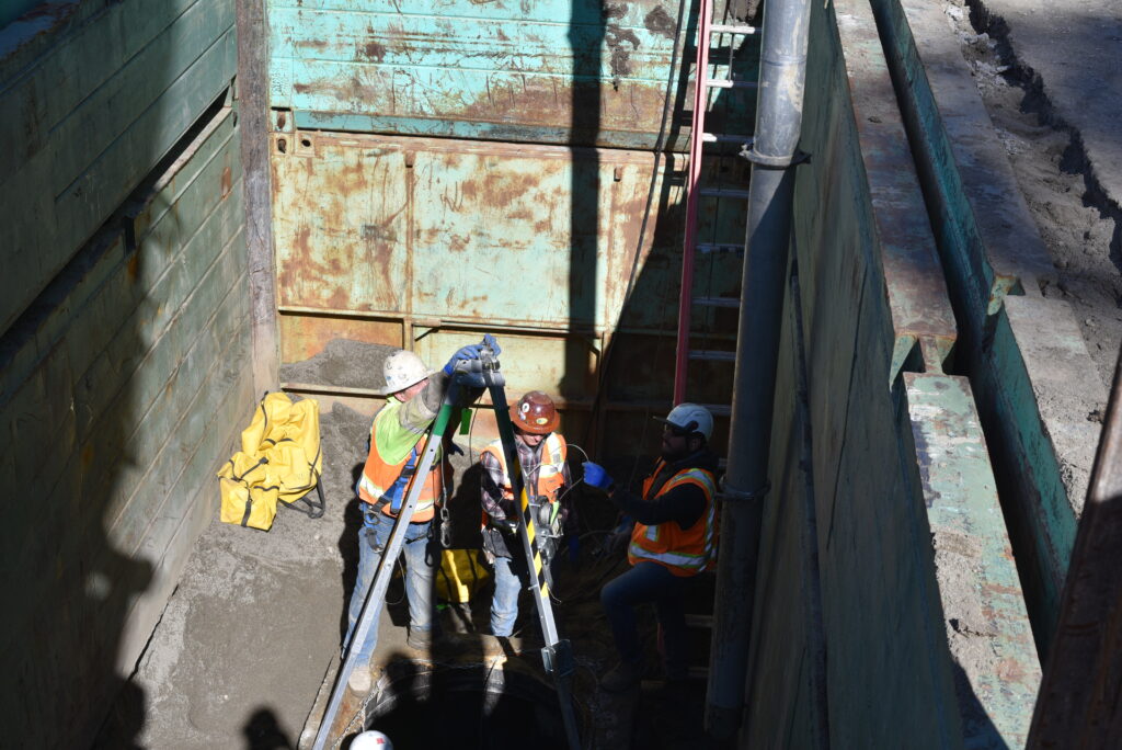 Three construction workers putting together a safety device